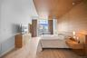 Bedroom featuring a wall of windows, light wood-style flooring, and baseboards