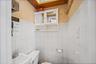 Half bathroom with tile walls and a skylight