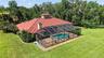 Aerial Rear View Showcasing the Home, Swimming Pool, Screen-Enclosed Lanai, and Backyard