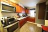 Kitchen featuring backsplash, a sink, stainless steel appliances, and reddish brown cabinets