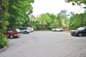 Uncovered parking lot featuring view of scattered trees
