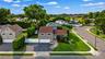 Corner property Split-level residence featuring a two-car garage, established landscaping, and a curvilinear paved driveway
