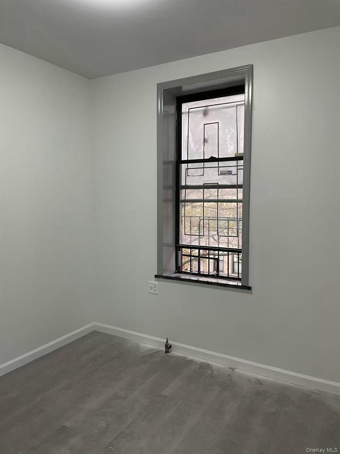 Unfurnished room with baseboards and concrete flooring