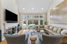 Living area featuring light wood-style floors, a premium fireplace, recessed lighting, and high vaulted ceiling