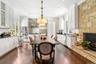 Dining room featuring crown molding, dark wood-style floors, a stone fireplace, and recessed lighting