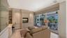 Primary bedroom lounge with extensive built-ins and sliding glass doors opening directly to the screened lanai, pool, and spa