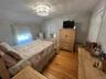Hardwood flooring, painted walls, window with blinds, and a built-in ceiling light fixture
