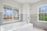 Bathroom with visible vents, tile walls, a whirlpool tub, and tile patterned flooring