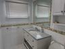 Bathroom featuring tile walls, toilet, and vanity