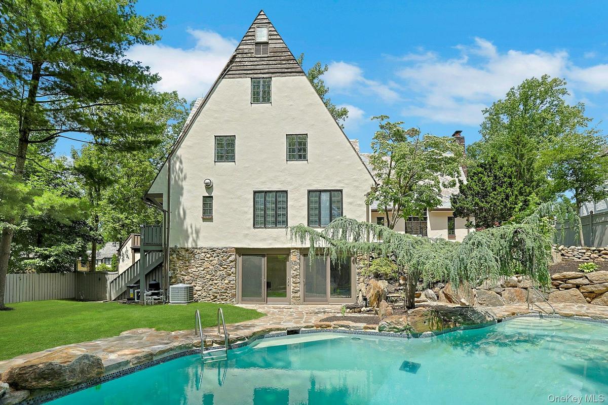 Another perspective of the stunning backyard with sparkling saltwater pool with a view of the large sliding glass doors leading to the recreation room
