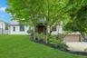Set on a beautifully landscaped property surrounded by mature trees, this exceptional home offers unparalleled curb appeal, a coveted slate roof, and