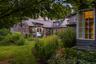 A beautifully landscaped courtyard transforms at dusk, creating an intimate outdoor setting surrounded by the warmth of the historic stone farmhouse a