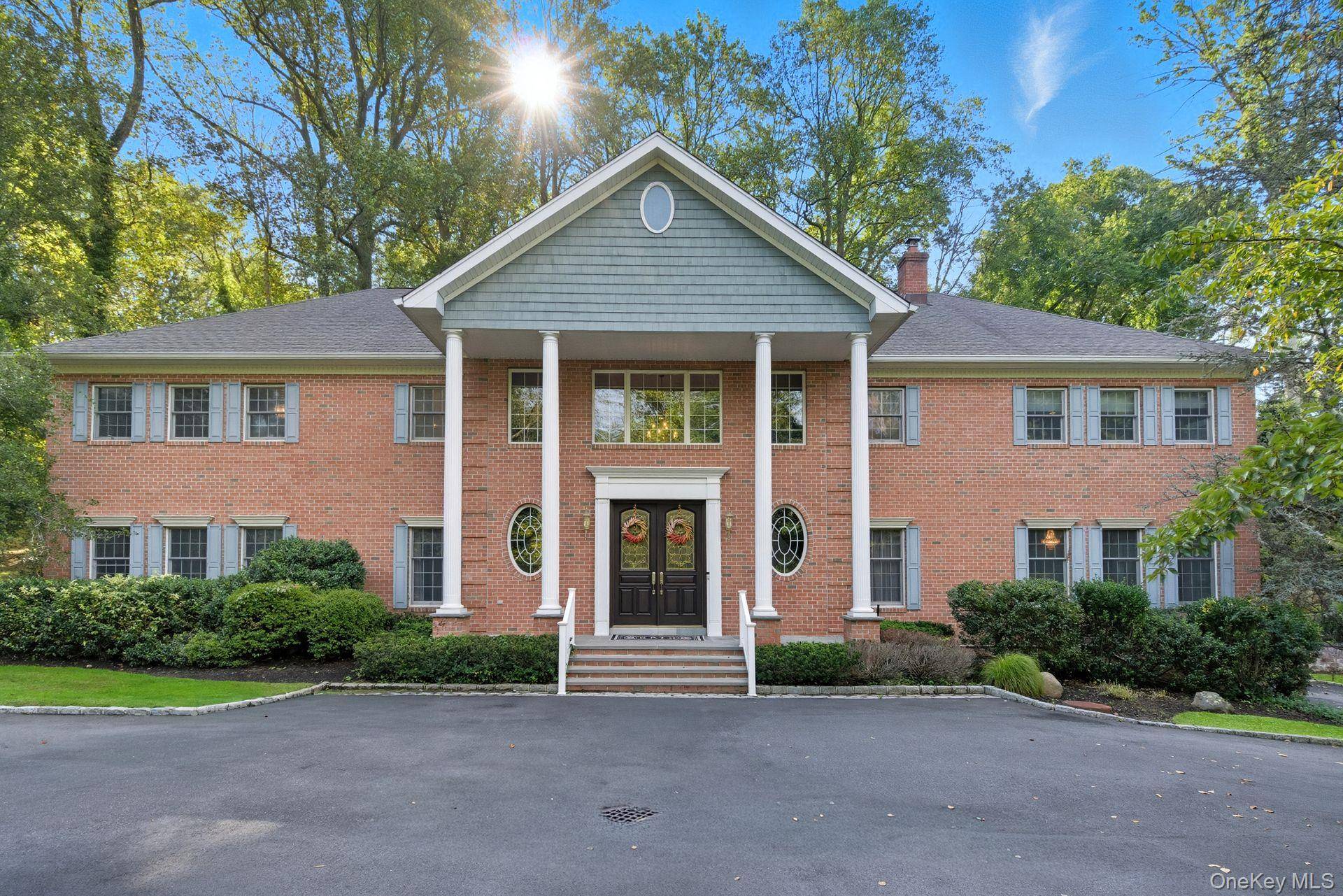 Stately 6, 600 sq. ft. brick Colonial set on 2 private acres with a pool in the desirable Lloyd Harbor area within the Cold Spring Harbor School District.
