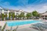 Community pool with a patio area and a residential view