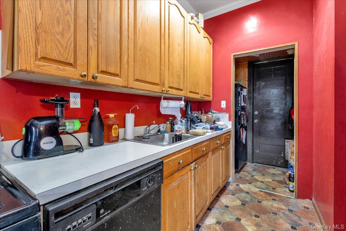 Kitchen with crown molding, black dishwasher, and sink