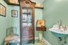 Staged Half bathroom featuring wallpapered walls and antique sink