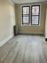 Spare room featuring radiator heating unit and light hardwood / wood-style floors