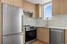 Kitchen featuring appliances with stainless steel finishes, modern cabinets, light stone countertops, and under cabinet range hood