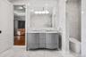 Bathroom with tile walls, double vanity, and marble finish flooring