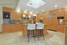 The chef's kitchen features custom oak cabinetry, granite countertops, premium appliances, and a large center island designed for gathering.