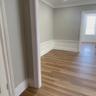 Empty room with dark wood-type flooring, a wainscoted wall, and a decorative wall