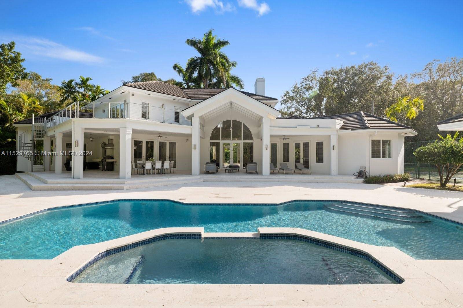 Located within the prestigious North Pinecrest area, this contemporary estate radiates sophistication and privacy.