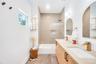 Bathroom featuring double vanity and tub / shower combination