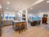 Kitchen featuring open floor plan, a center island, light wood-type flooring, a kitchen bar, and recessed lighting