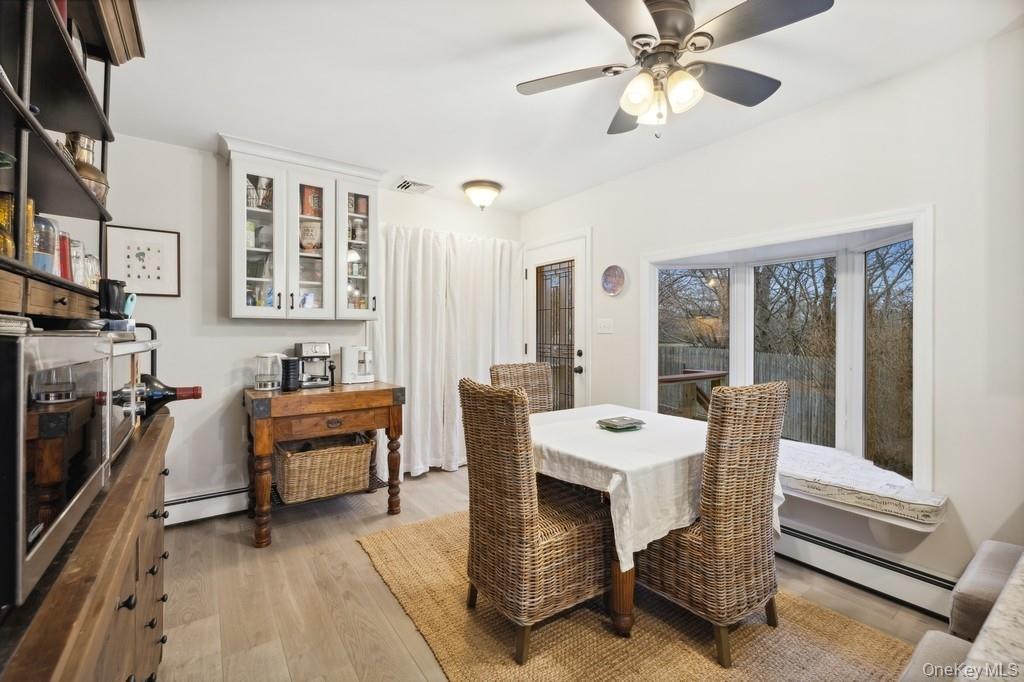 Dining area featuring a baseboard radiator, light wood-type flooring, and a ceiling fan