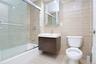 Bathroom featuring vanity, shower / bath combination with glass door, and tile walls
