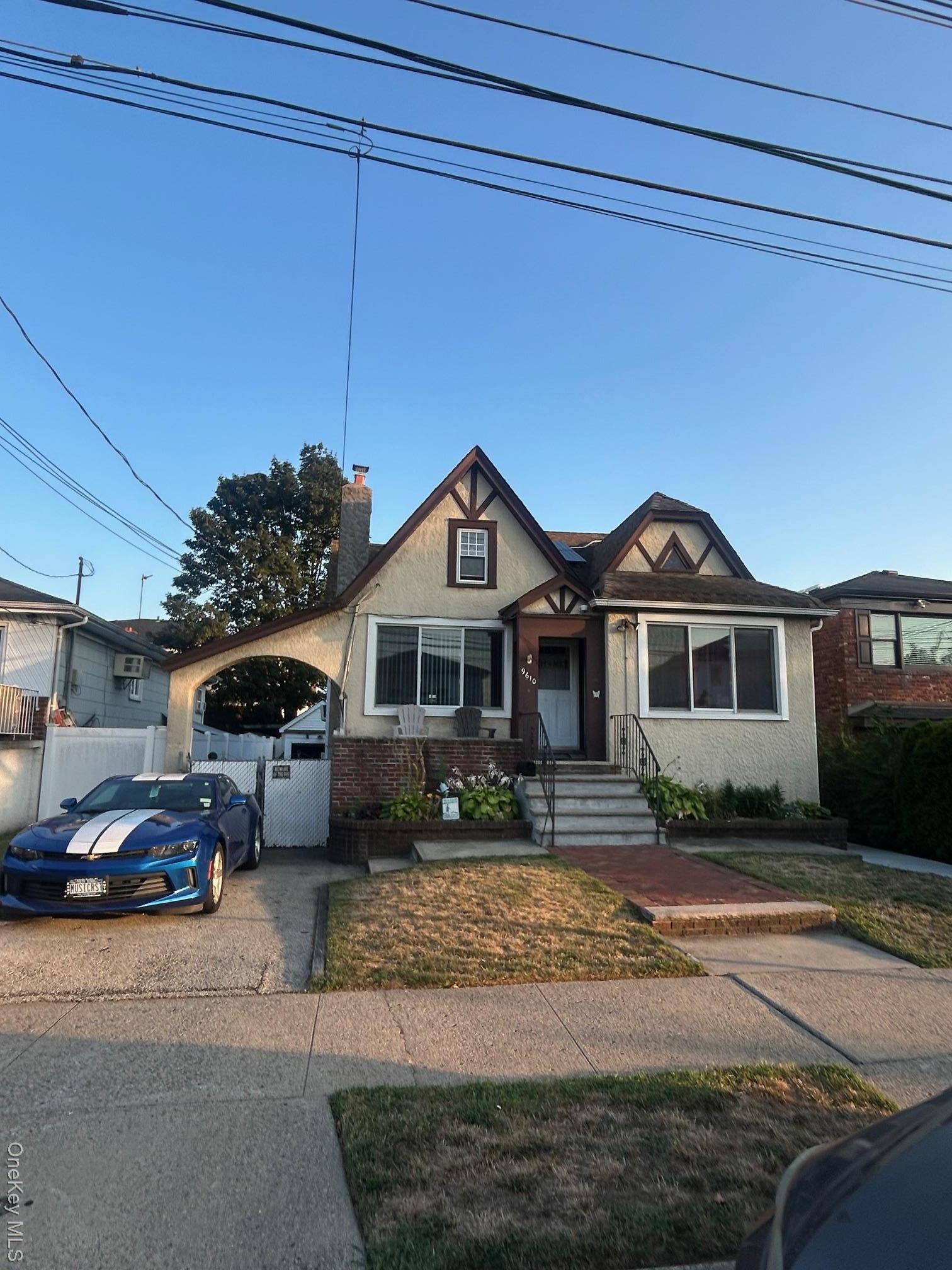 View of front of house featuring stucco siding, a chimney, and brick siding