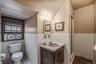 Full bath featuring vanity, tile walls, wainscoting, a shower stall, and tile patterned floors