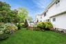 View of green lawn with a wooden deck