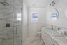 Bathroom featuring vanity, a shower with door, and toilet