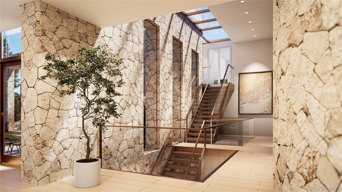 Stone-lined vestibule with floating steel, wood and glass staircase