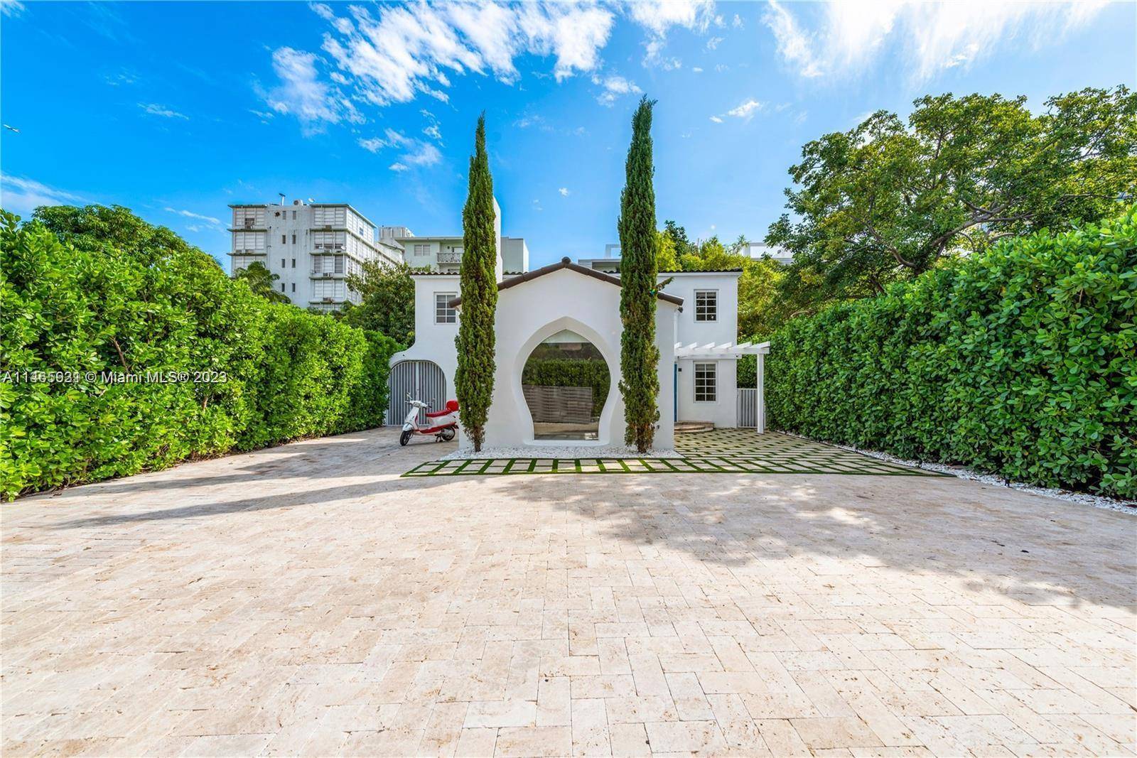 An Iconic Furnished Art Deco 'Palm View Historic District' home w an automatic gate that opens to your beautifully manicured paved driveway with a checkered grass inset.