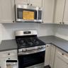 Kitchen with appliances with stainless steel finishes, dark countertops, and white cabinets