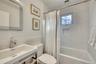 Bathroom with visible vents, toilet, a wainscoted wall, shower / bath combo with shower curtain, and a sink