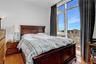 Bedroom featuring multiple windows, a city view, and light wood-style flooring