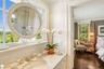 Ensuite bathroom featuring crown molding, vanity, and dark wood finished floors