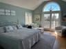 Bedroom featuring access to exterior, vaulted ceiling, and wood finished floors