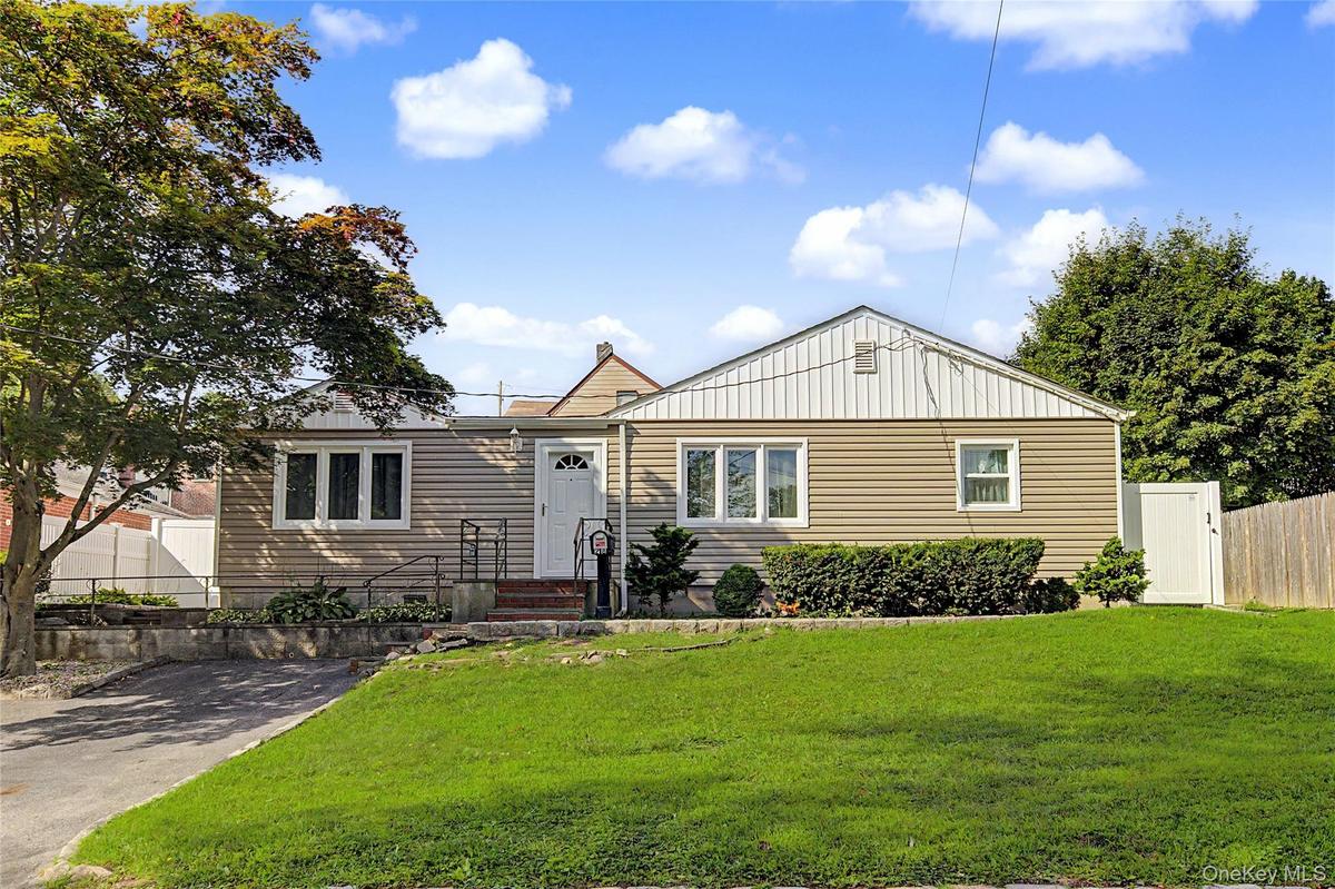 Charming ranch-style home featuring a gabled roof with metal accents, horizontal siding exterior, and a welcoming front entrance