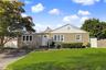 Charming ranch-style home featuring a gabled roof with metal accents, horizontal siding exterior, and a welcoming front entrance