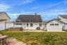 Back of house with solar panels, a hot tub, a fenced backyard, a patio area, and a chimney