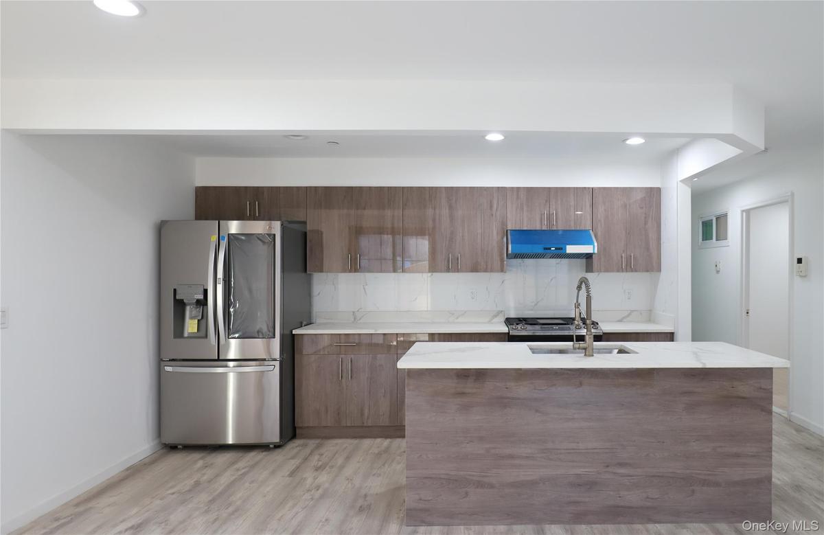 Kitchen with stainless steel appliances, tasteful backsplash, light stone countertops, recessed lighting, and modern cabinets