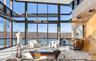 Living room with a fireplace, a towering ceiling, and a water view