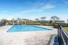 Community pool with fence, a pergola, and a patio
