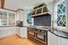 Kitchen featuring glass insert cabinets, dark countertops, range with two ovens, white cabinets, and recessed lighting