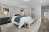 Bright and spacious primary bedroom with hardwood floors, crown molding, and direct access to the ensuite bath.