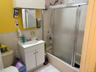 Bathroom featuring vanity, shower / bath combination with glass door, tile walls, and light tile patterned floors